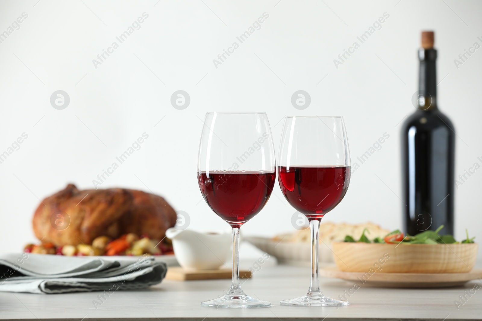 Photo of Red wine and delicious dinner served on light table