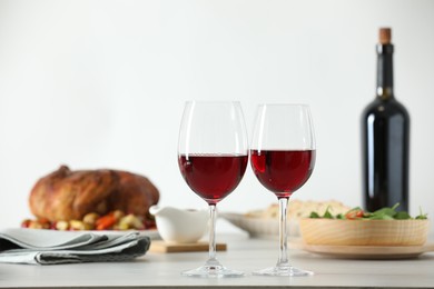 Photo of Red wine and delicious dinner served on light table