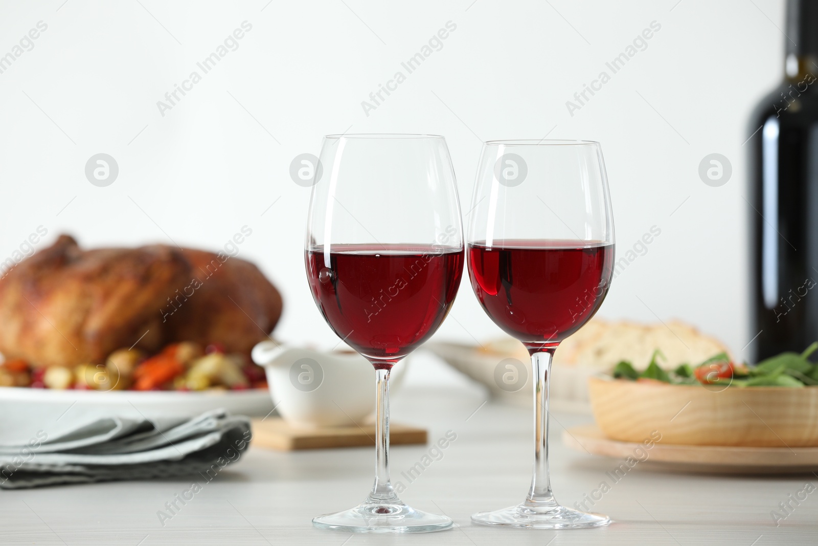 Photo of Red wine and delicious dinner served on light table