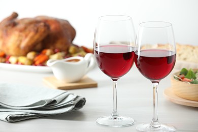 Photo of Red wine and delicious dinner served on light table