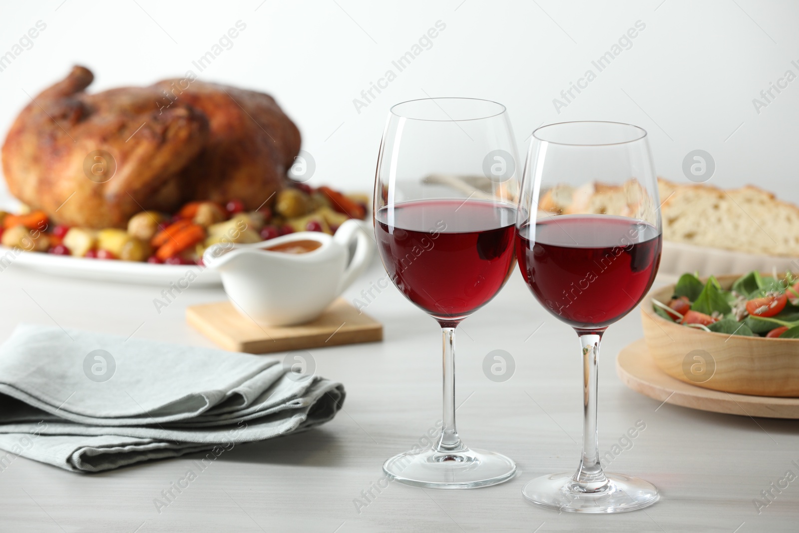 Photo of Red wine and delicious dinner served on light table