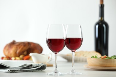 Photo of Red wine and delicious dinner served on light table