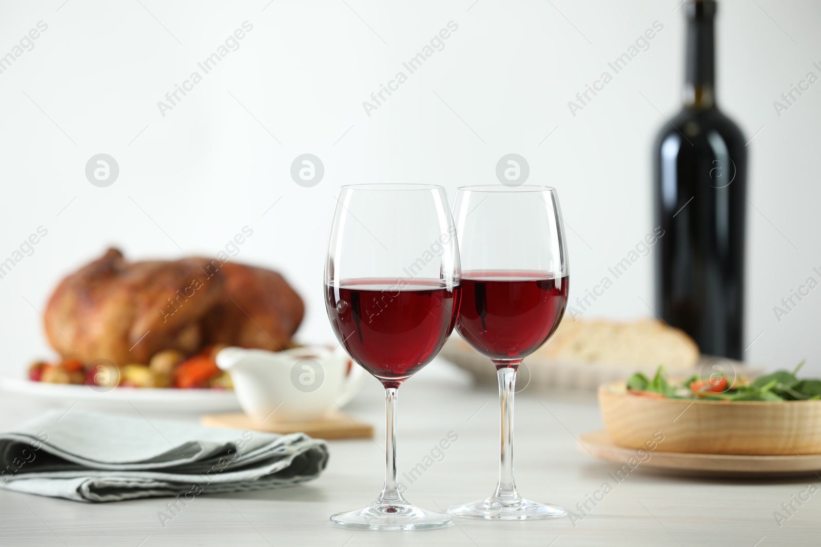 Photo of Red wine and delicious dinner served on light table