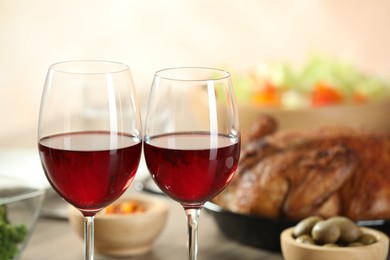 Photo of Red wine and delicious dinner served on table, closeup. Space for text