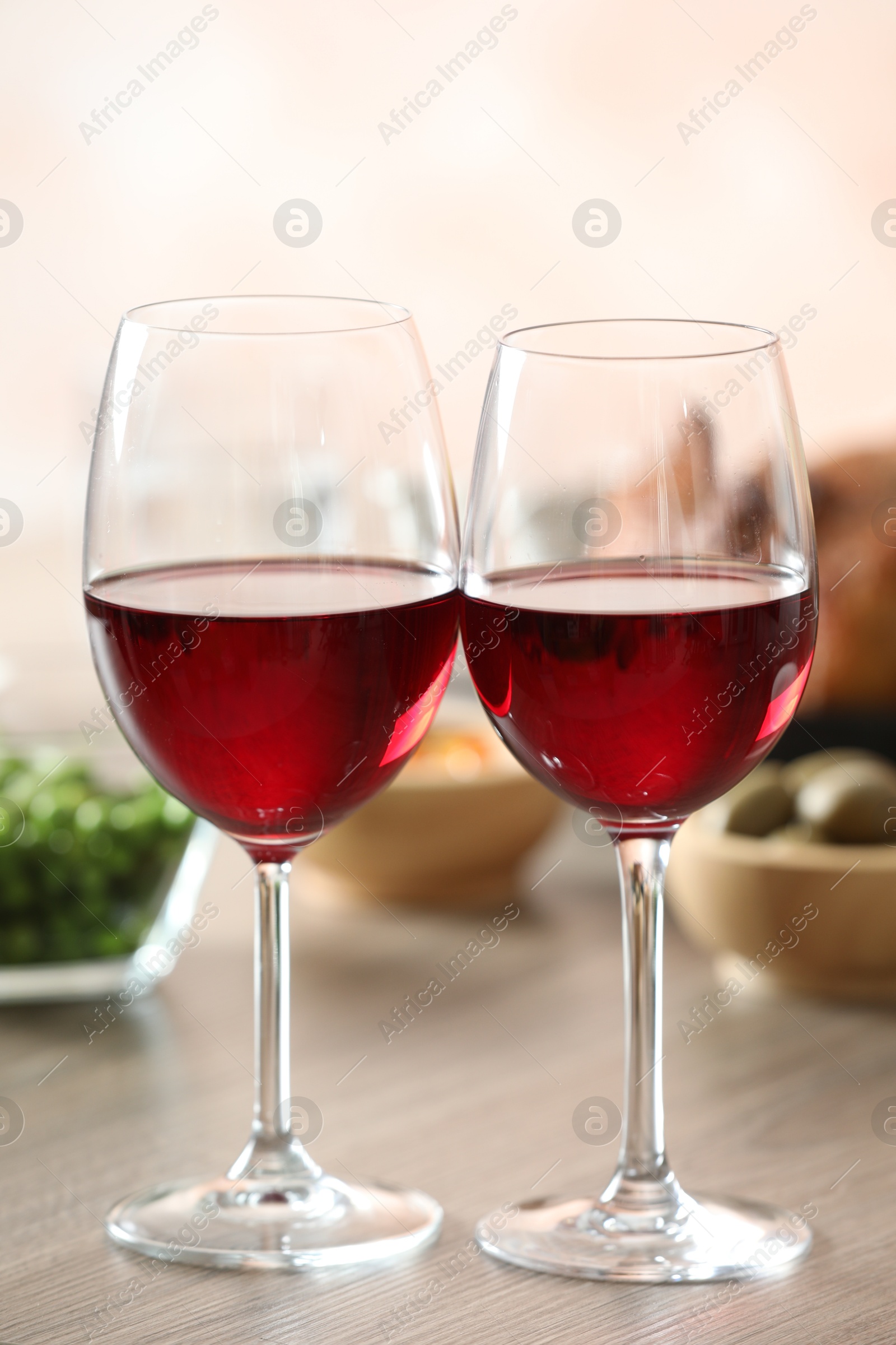 Photo of Red wine and delicious dinner served on wooden table, closeup