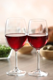 Photo of Red wine and delicious dinner served on wooden table, closeup