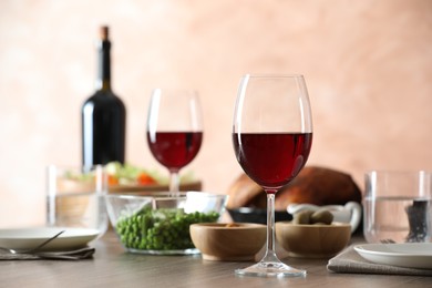 Photo of Red wine and delicious dinner served on wooden table