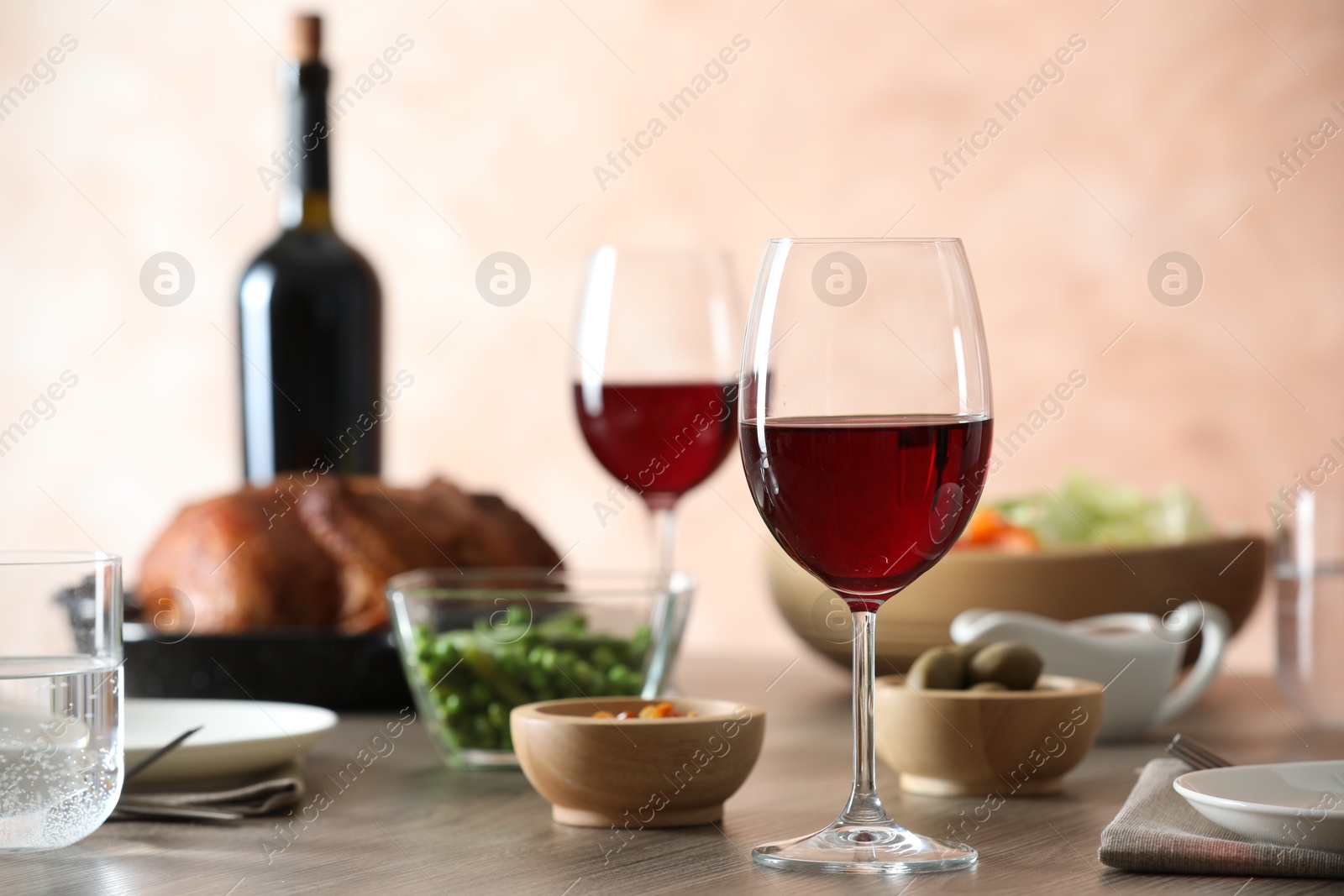 Photo of Red wine and delicious dinner served on wooden table