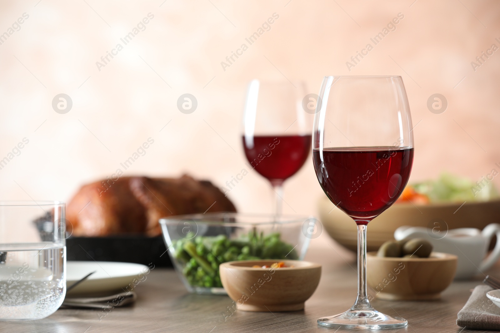 Photo of Red wine and delicious dinner served on wooden table