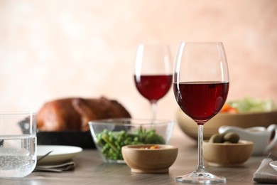 Photo of Red wine and delicious dinner served on wooden table