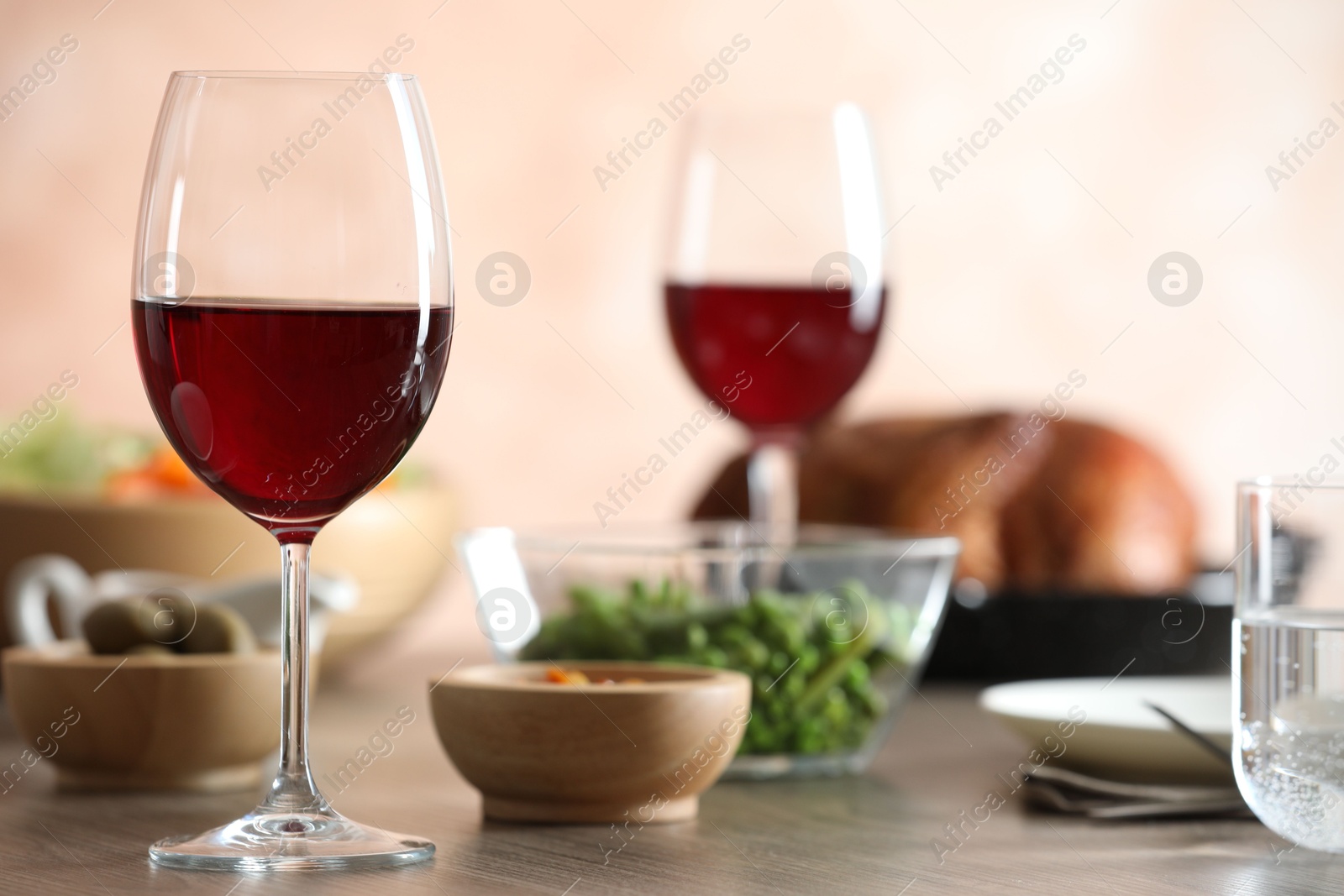 Photo of Red wine and delicious dinner served on wooden table, closeup