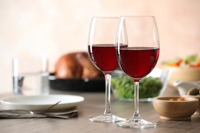 Photo of Red wine and delicious dinner served on wooden table