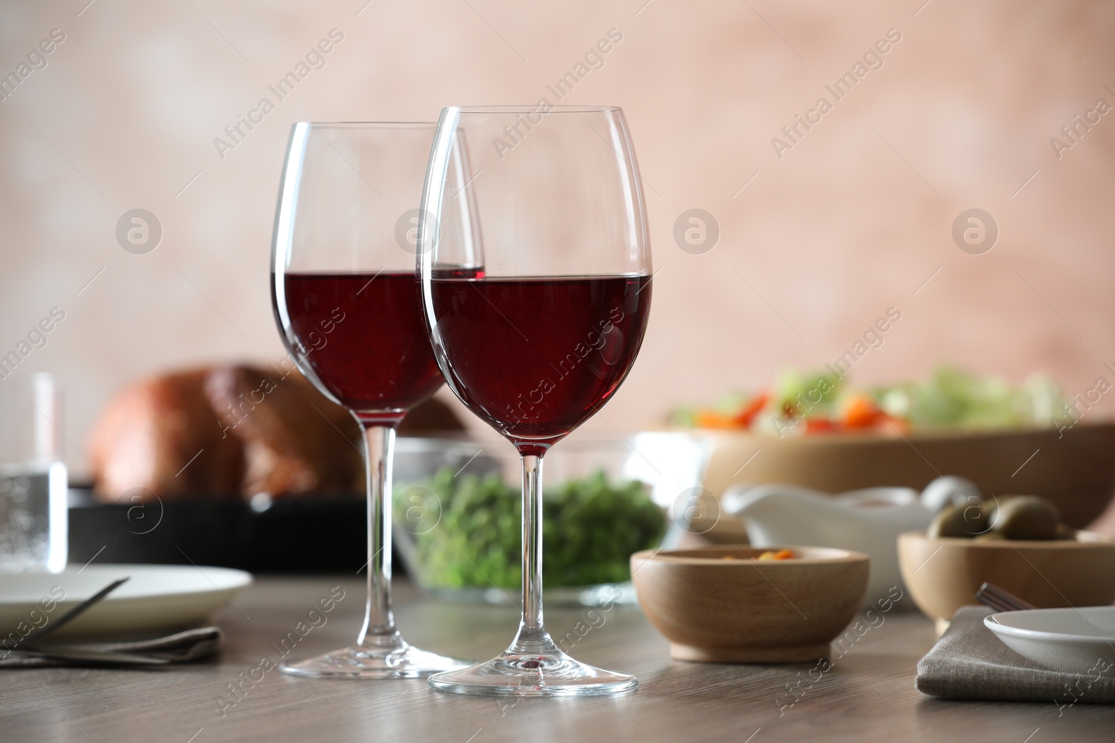 Photo of Red wine and delicious dinner served on wooden table