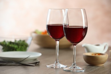 Photo of Red wine and delicious dinner served on wooden table