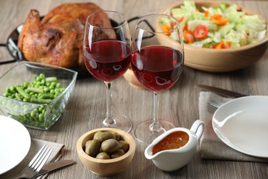 Photo of Red wine and delicious dinner served on wooden table