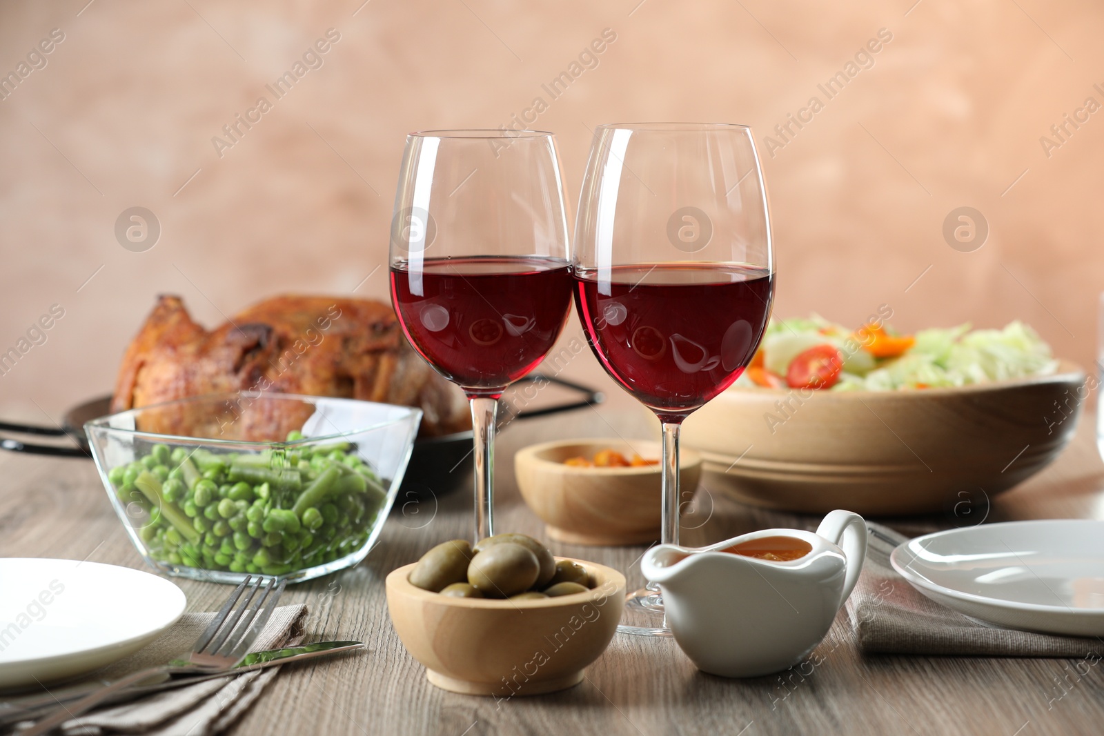 Photo of Red wine and delicious dinner served on wooden table