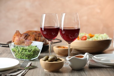 Photo of Red wine and delicious dinner served on wooden table