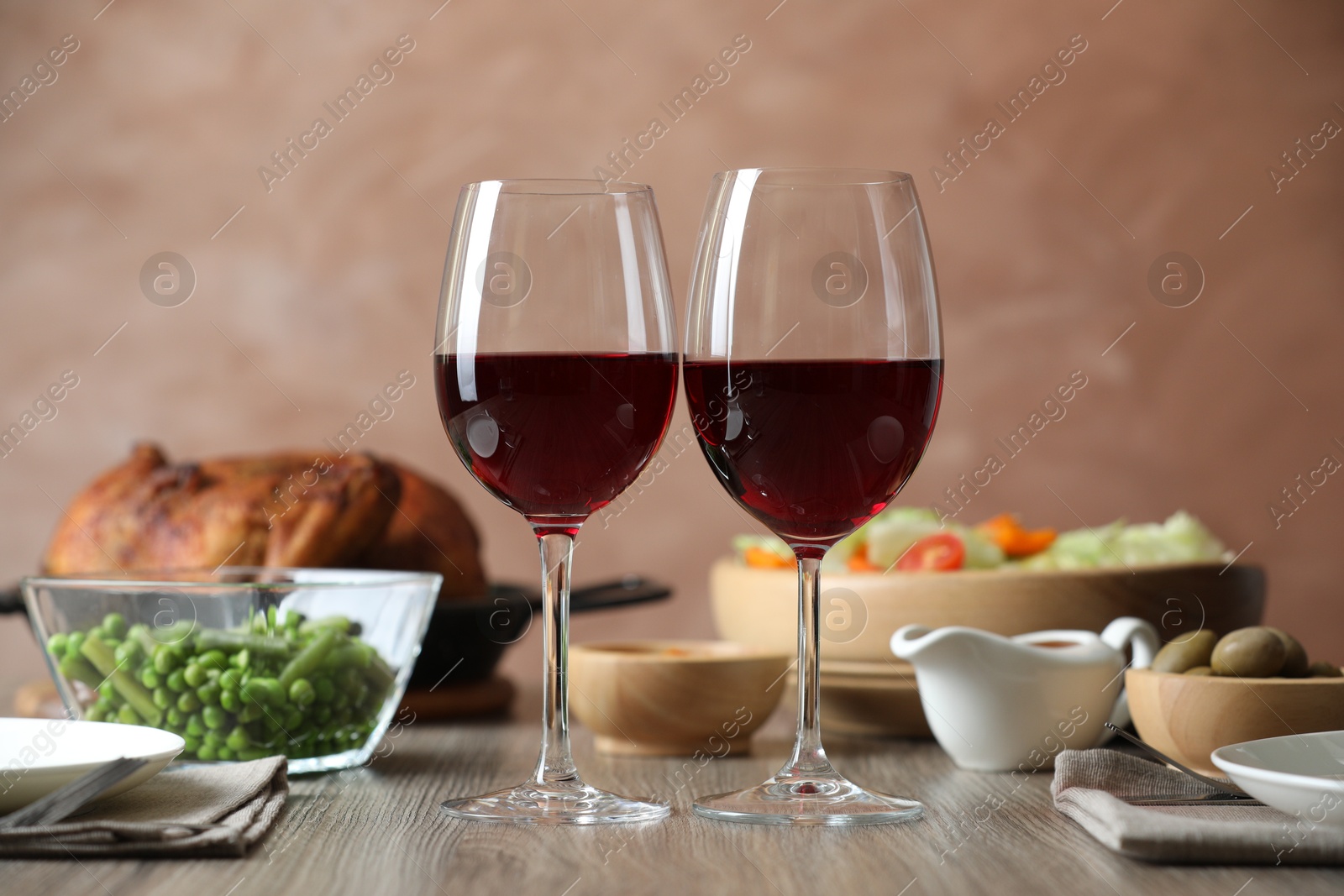 Photo of Red wine and delicious dinner served on wooden table