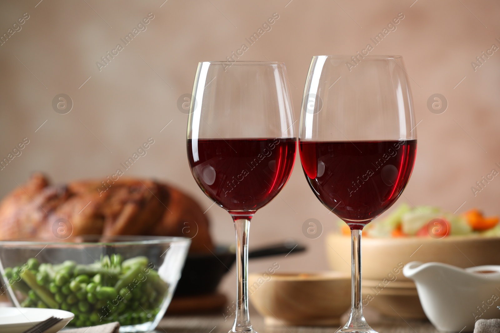 Photo of Red wine and delicious dinner served on table, closeup