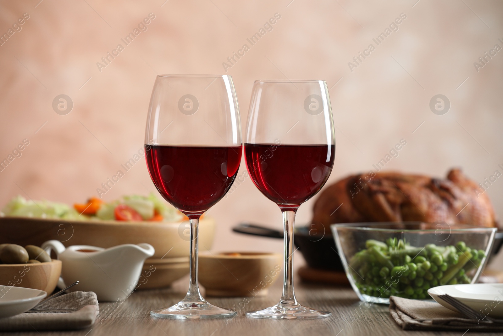 Photo of Red wine and delicious dinner served on wooden table