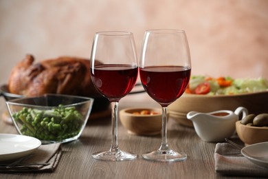 Photo of Red wine and delicious dinner served on wooden table