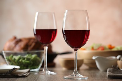 Photo of Red wine and delicious dinner served on wooden table