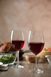 Photo of Red wine and delicious dinner served on wooden table