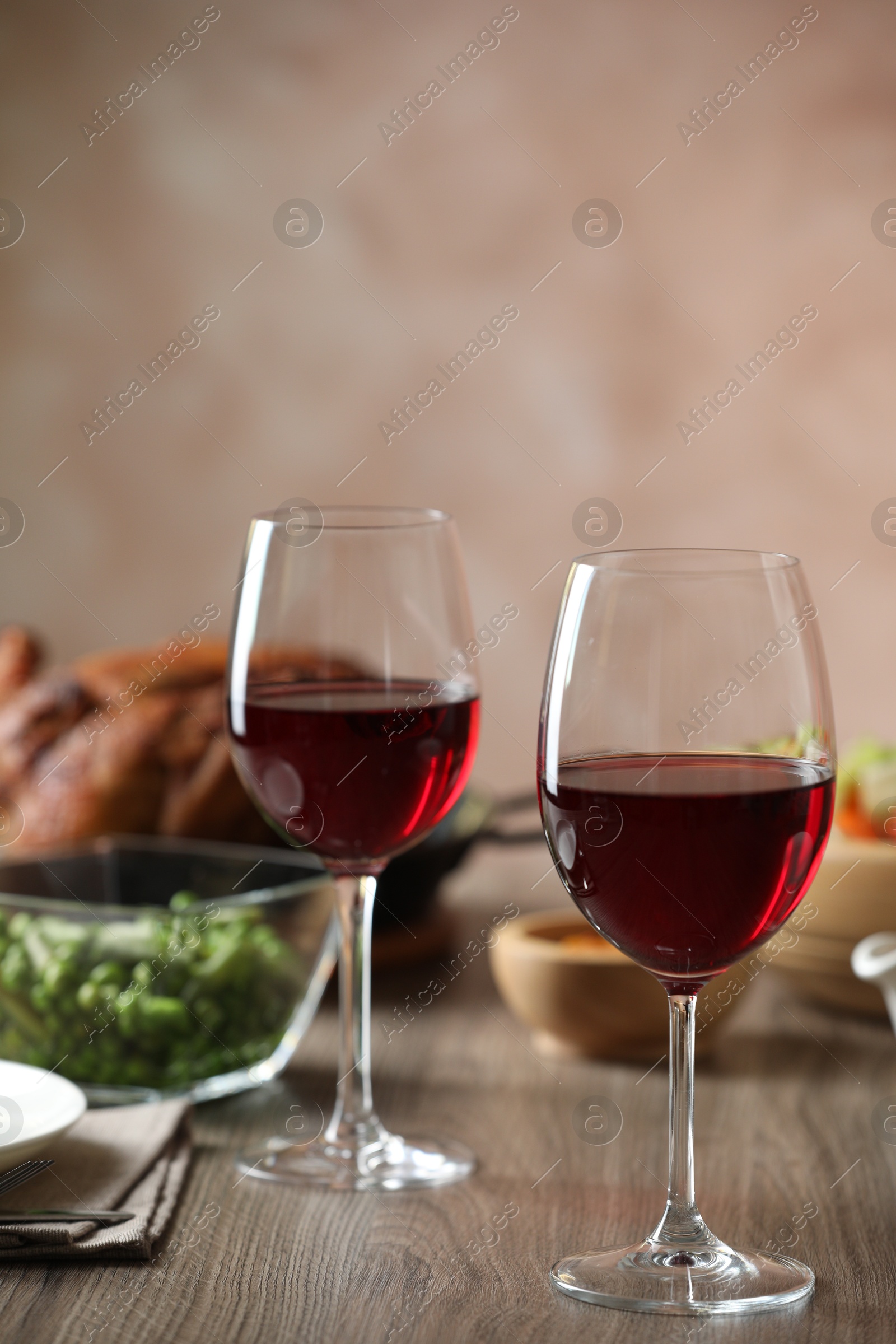 Photo of Red wine and delicious dinner served on wooden table