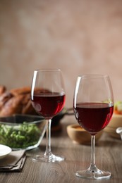 Photo of Red wine and delicious dinner served on wooden table