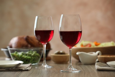 Photo of Red wine and delicious dinner served on wooden table