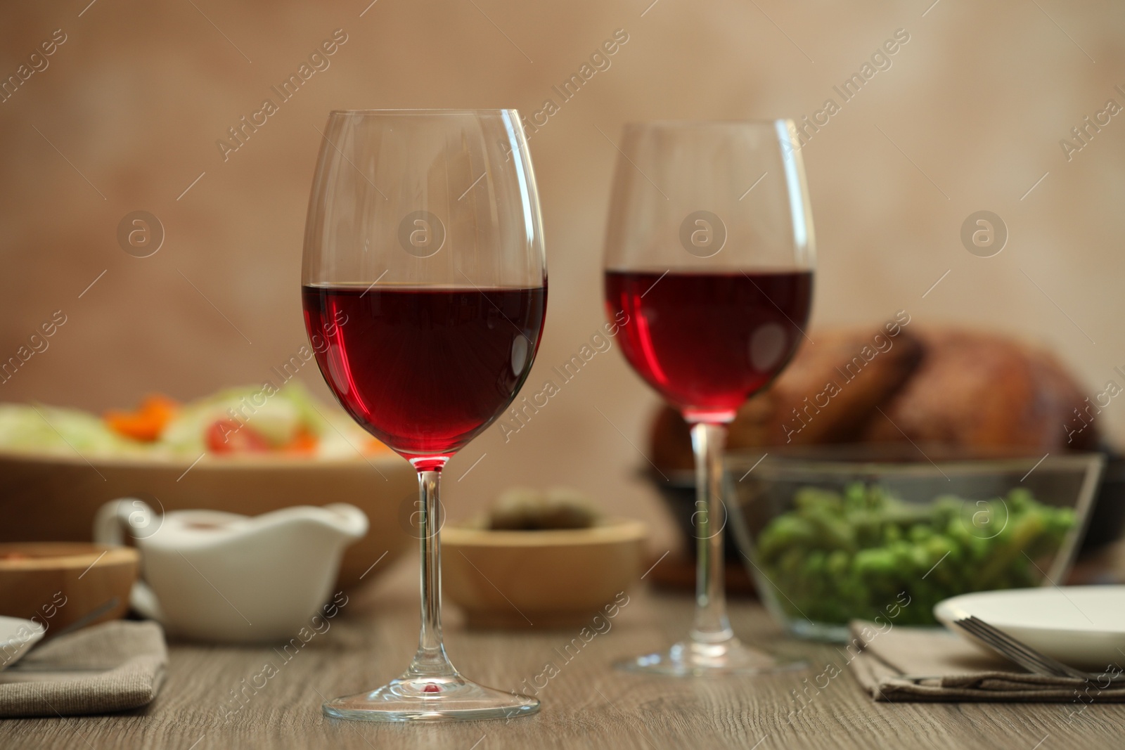 Photo of Red wine and delicious dinner served on wooden table