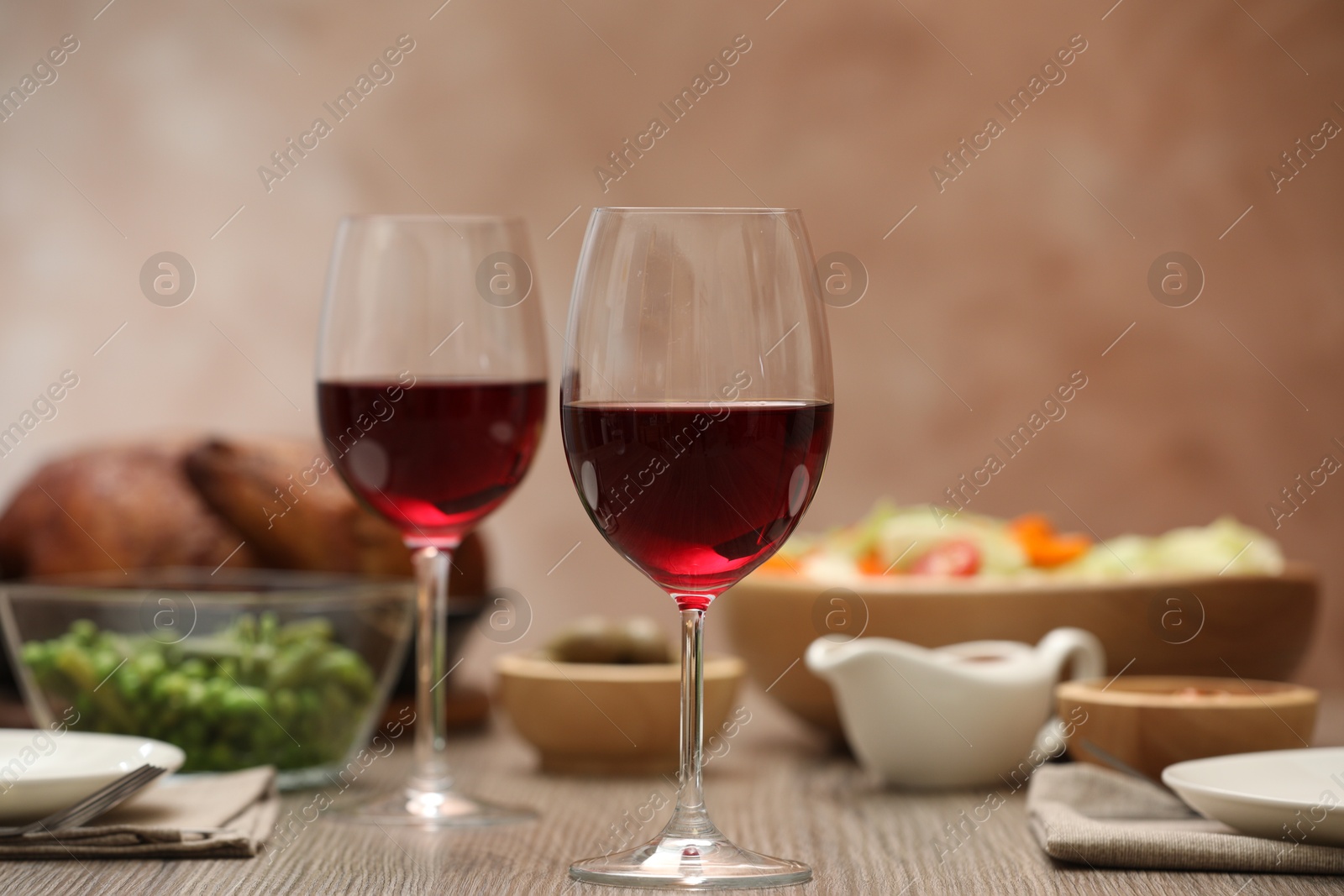 Photo of Red wine and delicious dinner served on wooden table