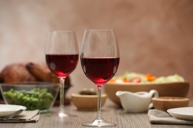 Photo of Red wine and delicious dinner served on wooden table