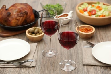 Photo of Red wine and delicious dinner served on wooden table