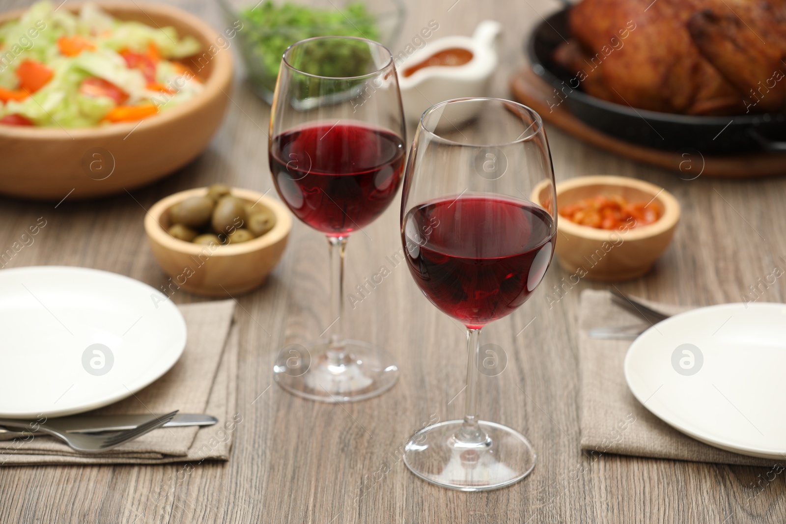 Photo of Red wine and delicious dinner served on wooden table