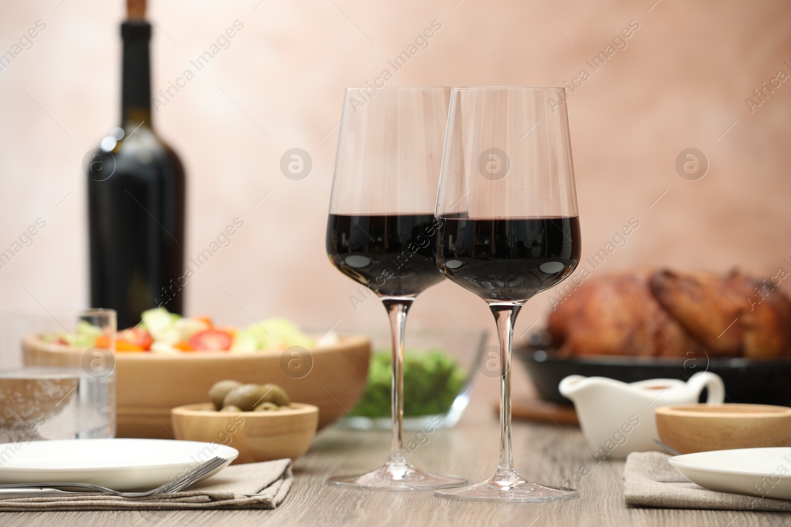 Photo of Red wine and delicious dinner served on wooden table