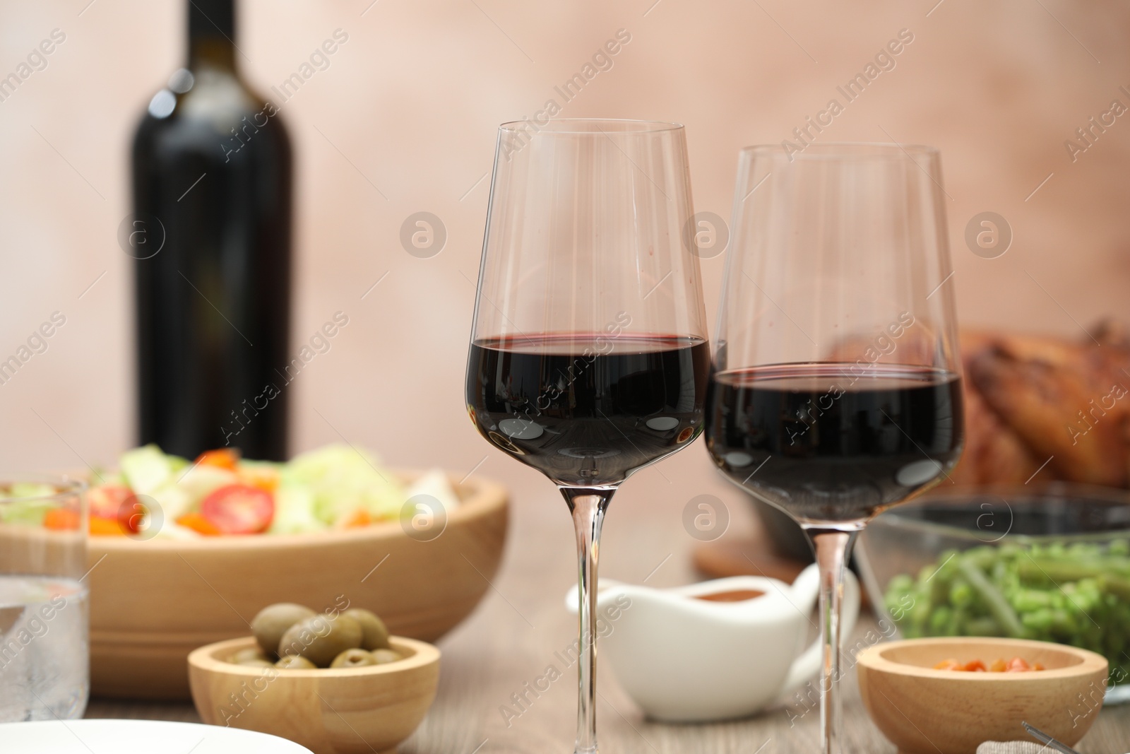 Photo of Red wine and delicious dinner served on table, closeup. Space for text