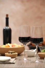 Photo of Red wine and delicious dinner served on wooden table