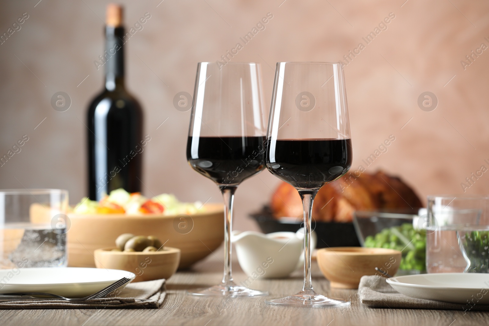 Photo of Red wine and delicious dinner served on wooden table