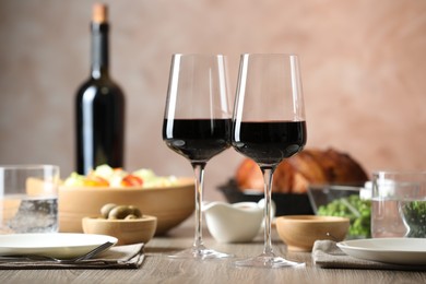 Photo of Red wine and delicious dinner served on wooden table