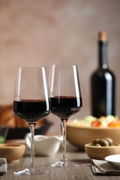 Photo of Red wine and delicious dinner served on wooden table