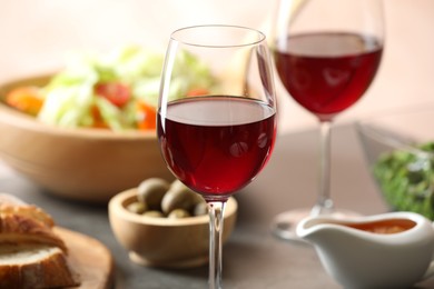 Photo of Red wine and delicious dinner served on table, closeup