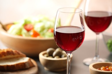 Photo of Red wine and delicious dinner served on table, closeup. Space for text