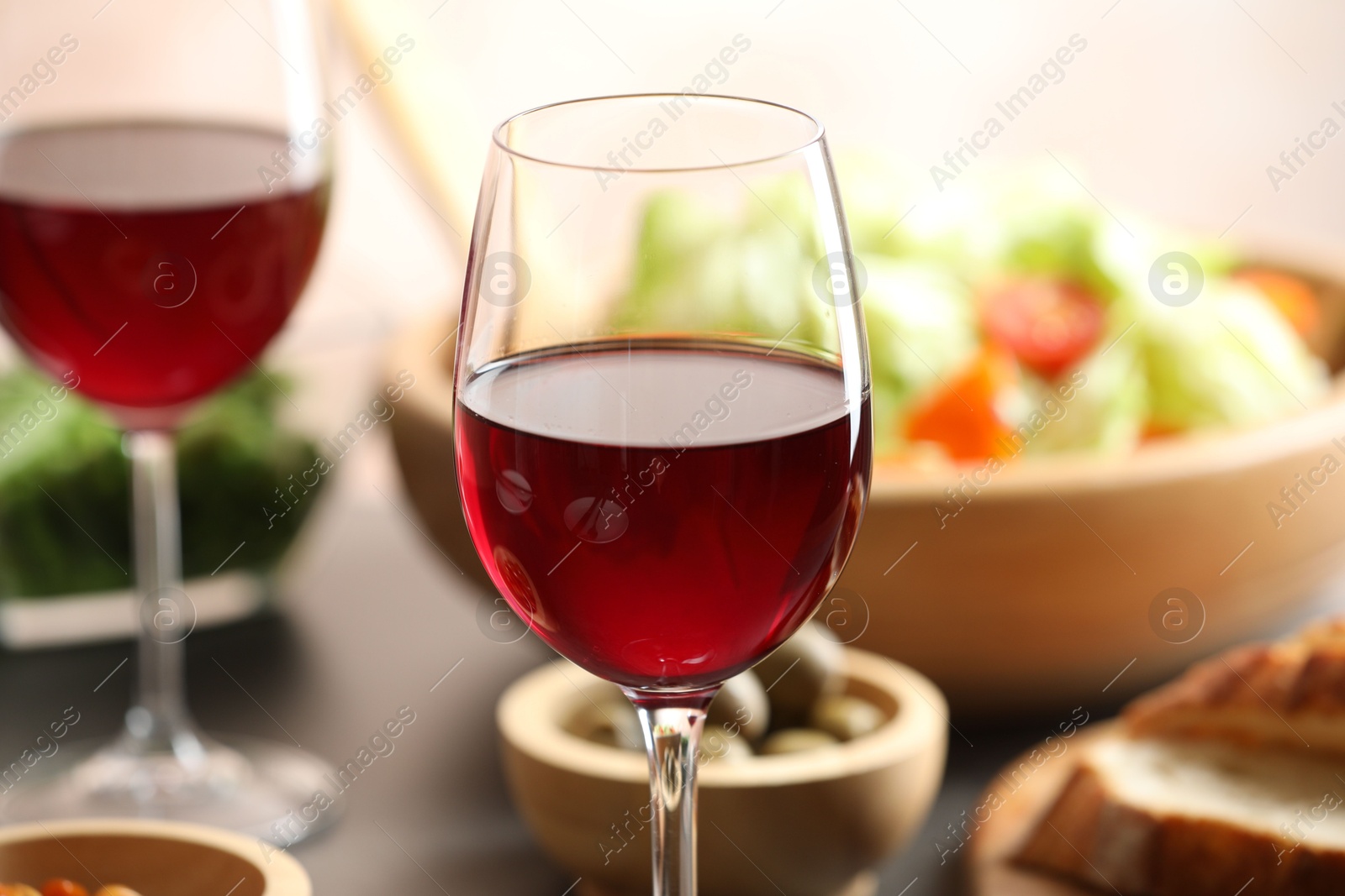 Photo of Red wine and delicious dinner served on table, closeup