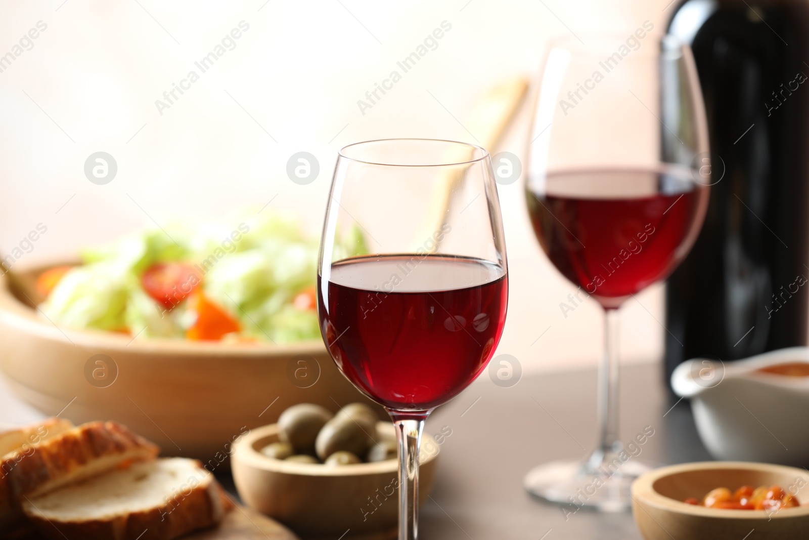 Photo of Red wine and delicious dinner served on table, closeup