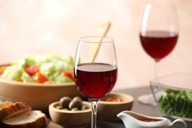 Photo of Red wine and delicious dinner served on table, closeup