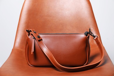 Photo of Stylish brown leather bag on chair, closeup