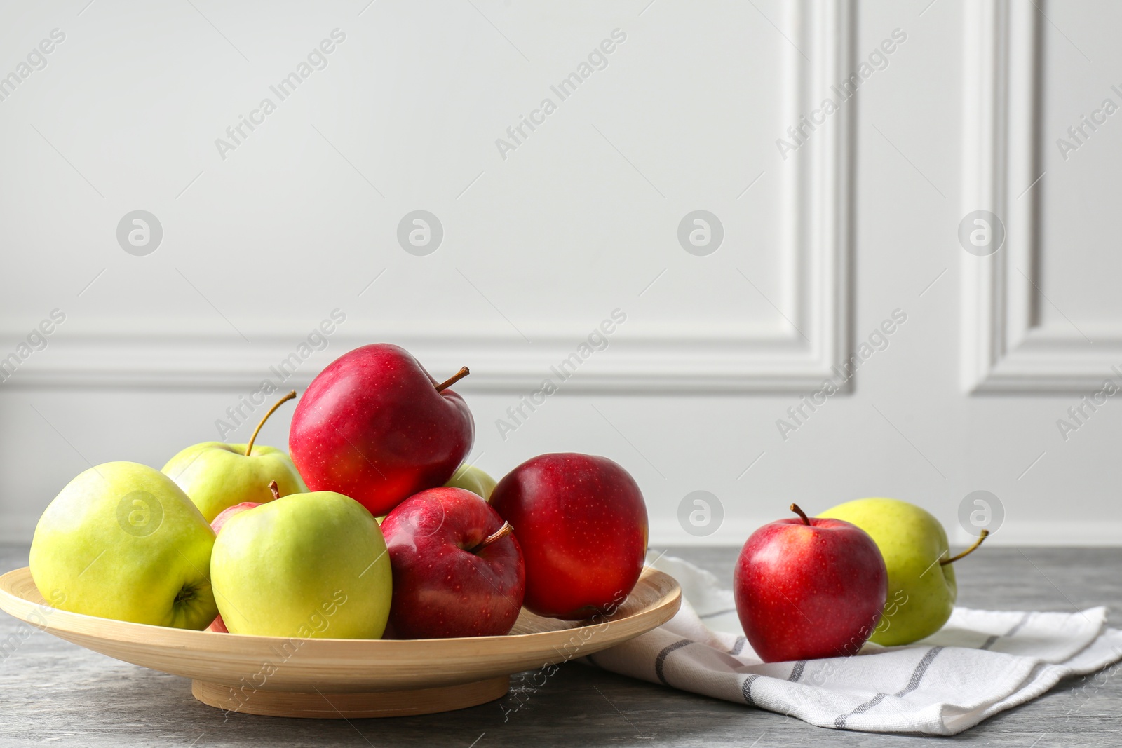 Fresh red and green apples on grey table Photo of Fresh red and green apples on grey table