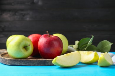 Photo of Fresh red and green apples on light blue wooden table