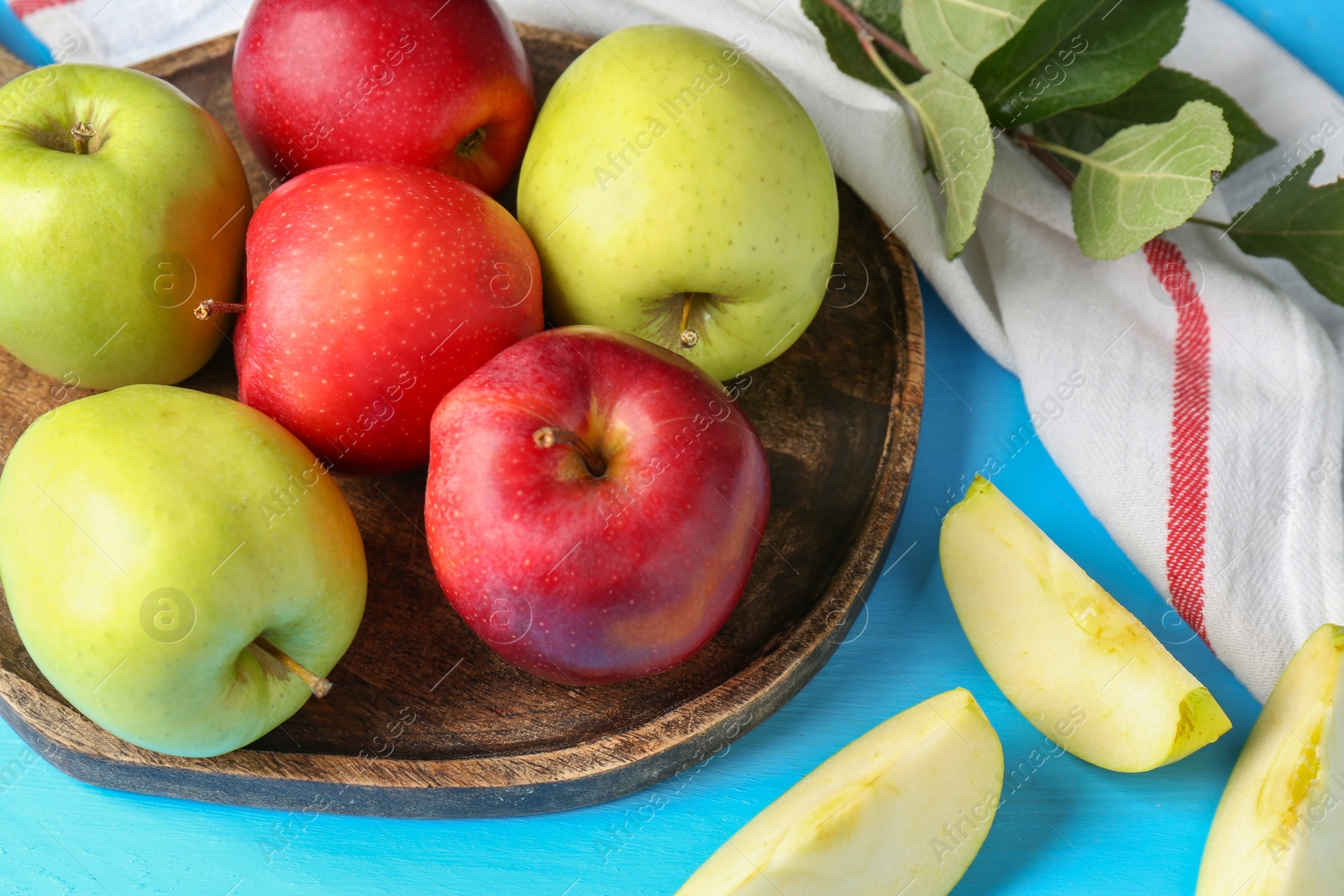 Photo of Fresh red and green apples on light blue wooden table